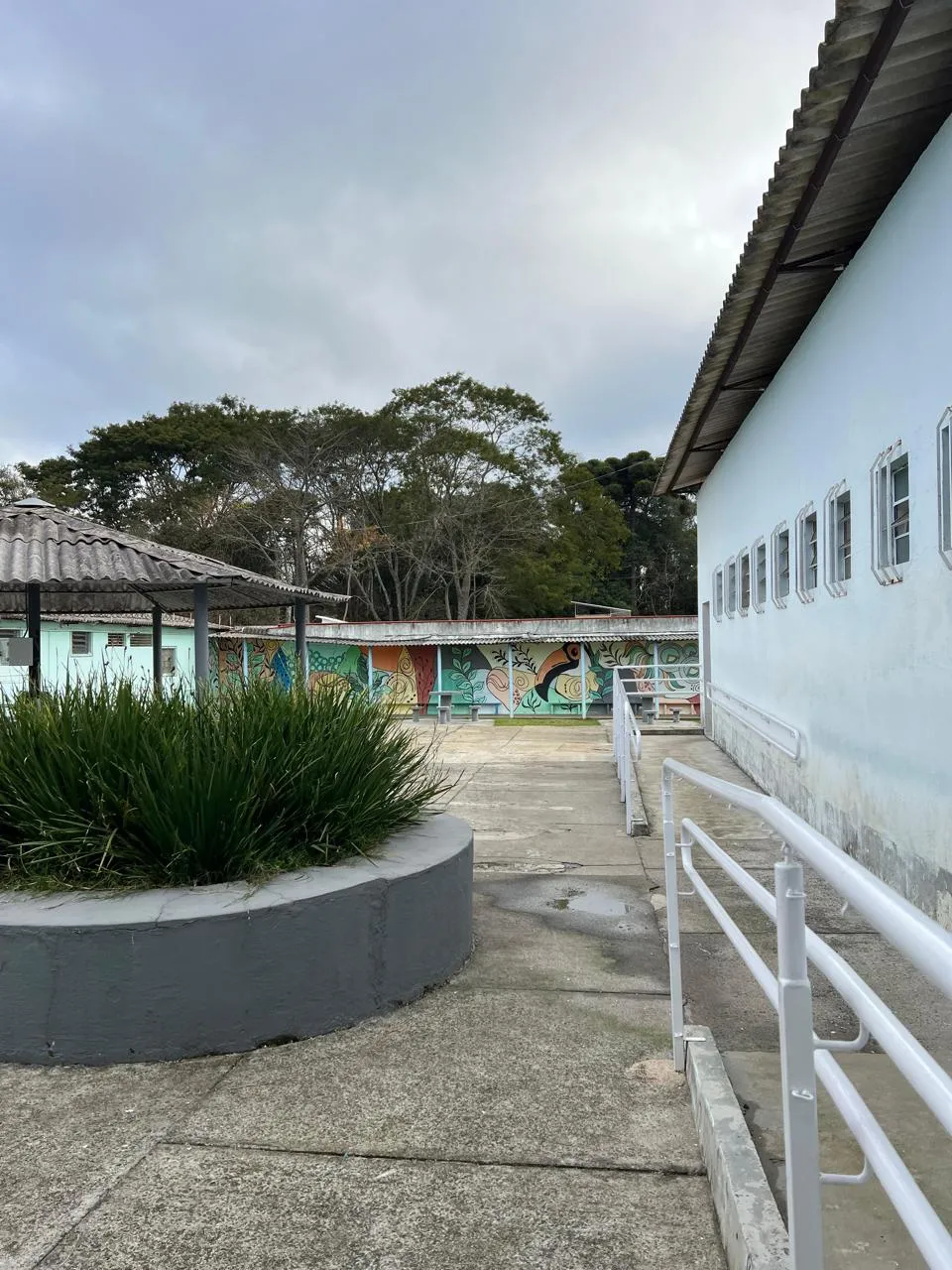 Área externa da Unidade Bion, com pátio, área coberta e mural colorido